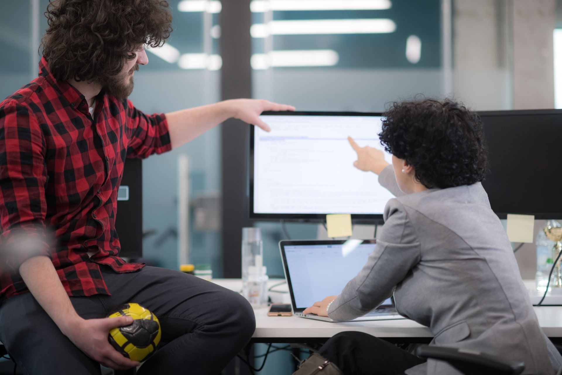 young software developers couple using laptop and desktop computer while writing programming code at modern creative startup office